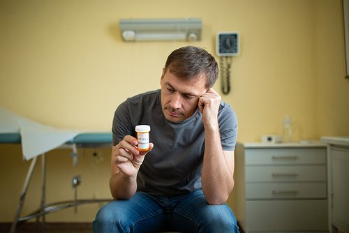 Мужчина сидит в подавленном состоянии
